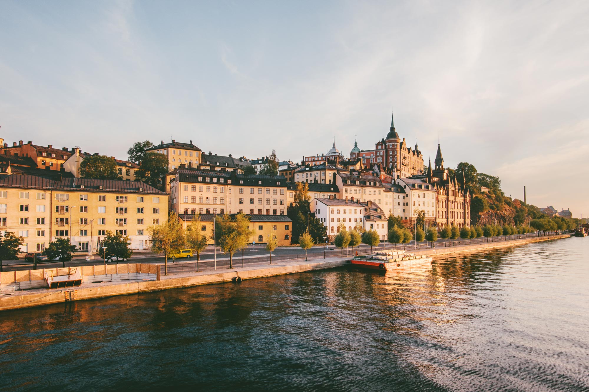 En vacker kvällsbild av Stockholm visar den pittoreska stadsvyn vid Södermalm med historiska och färgglada byggnader längs vattenkanten.